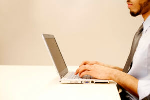 Person Wearing White Shirt And Tie Working On Laptop