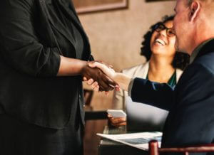 Man And Woman Shaking Hands In Immigration Seminar